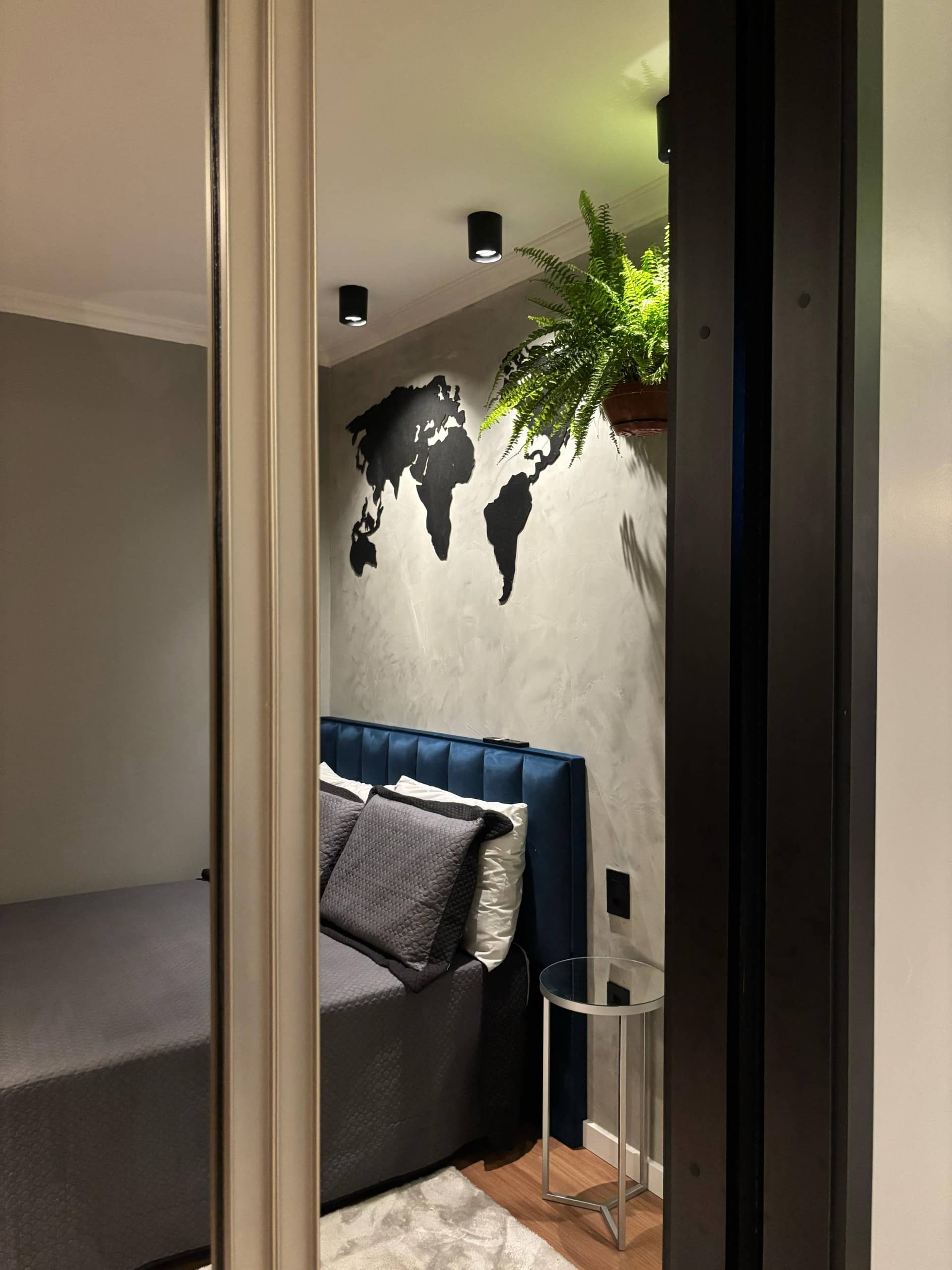 Quarto visto pelo espelho, com o mapa-múndi ao fundo