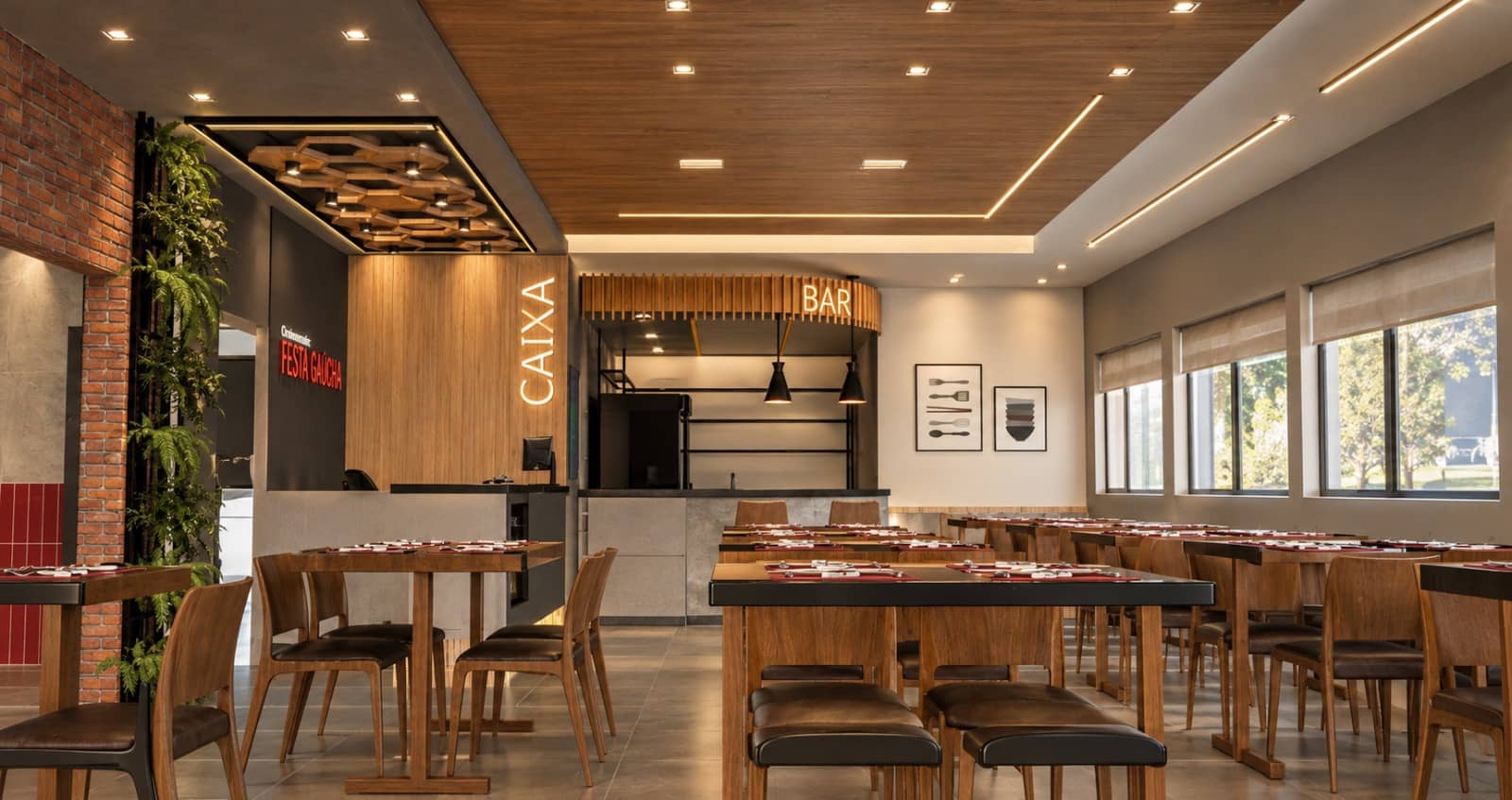 Salão do restaurante com mesas de madeira, forro amadeirado e caixa ao fundo