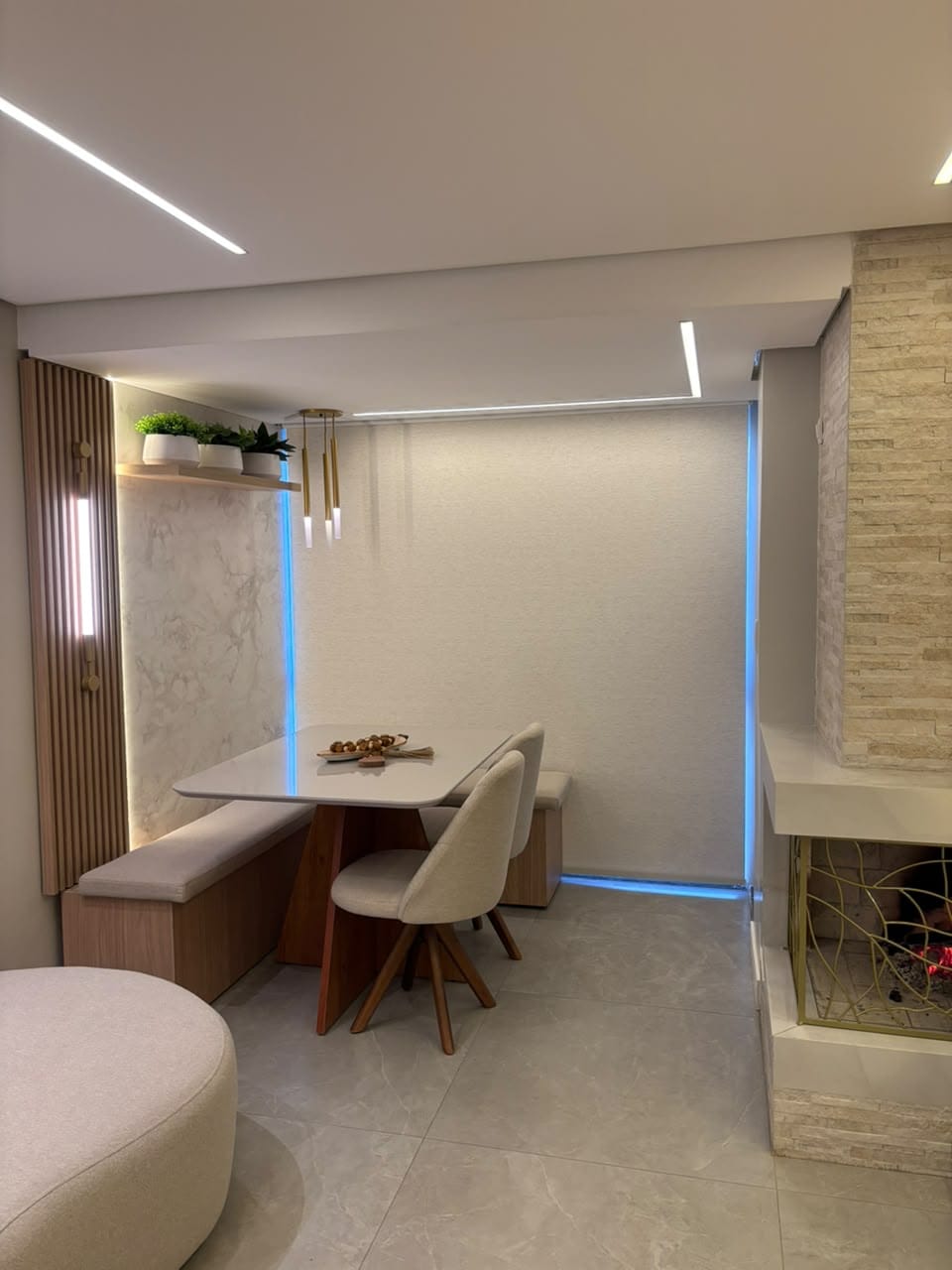 Canto de jantar com banco, cadeiras e perfis de LED no teto