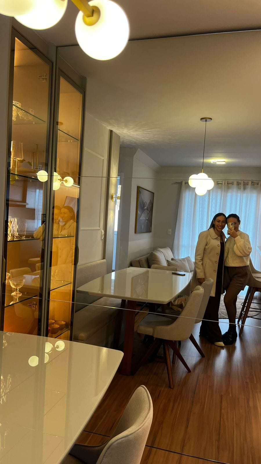 Sala de jantar com cristaleira e janelas ao fundo