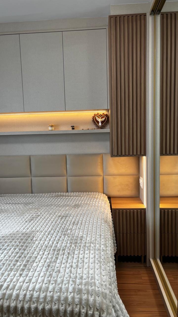 Quarto com cabeceira estofada, ripado e iluminação indireta
