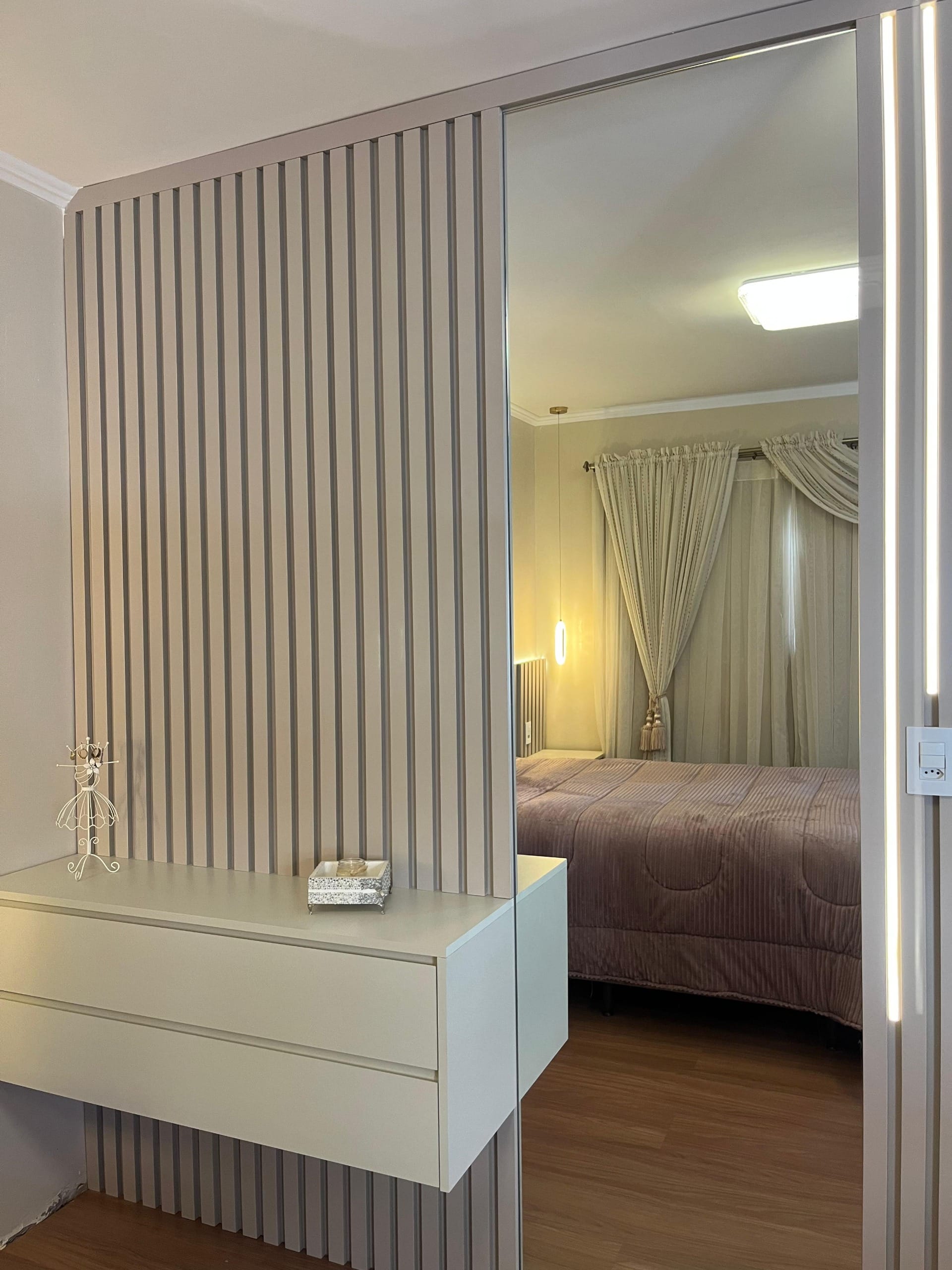 Quarto com ripado claro e mesa de cabeceira suspensa